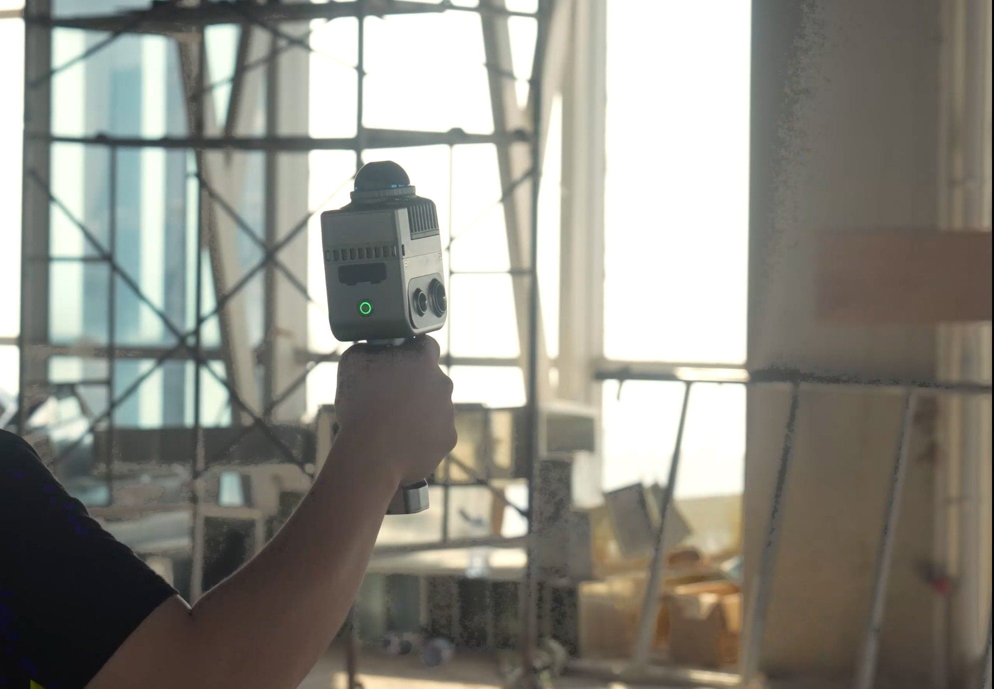 Field technician documenting exposed structural framing with a 3D scanner